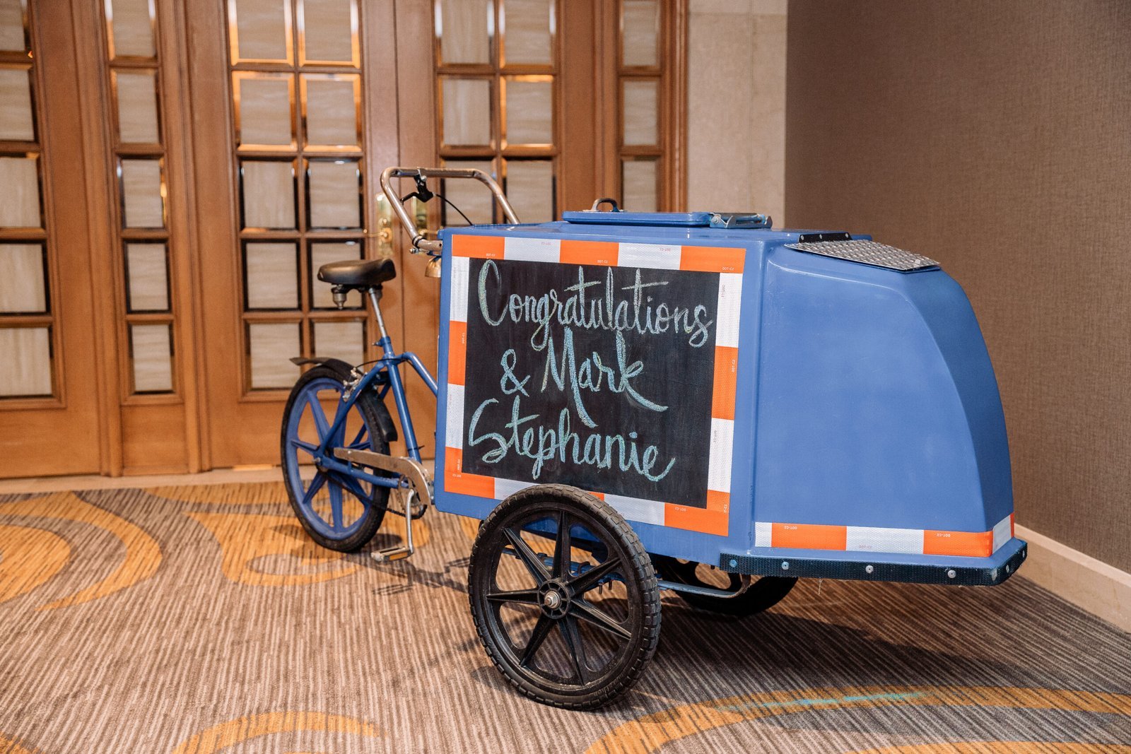 Ed’s blue ice cream bike ready for a wedding, with a personalized chalkboard